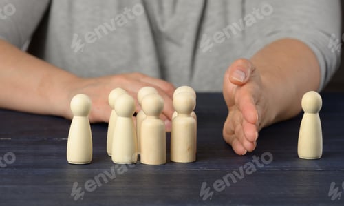 Preview: Female hand between wooden figures of men on a blue background
