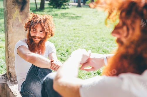Preview: Two bearded men with red hair shaking hands outdoors