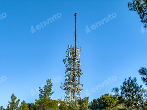 Preview: Telecommunication tower above forest under clear sky