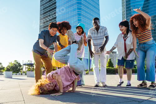 Preview: Multiethnic group of young friends meeting and having fun outdoors