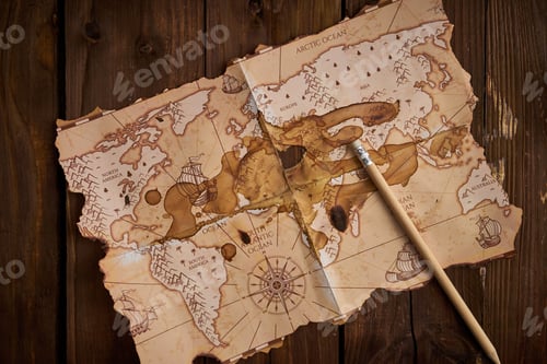 Preview: Antique-style world map with a pencil on the wooden table.