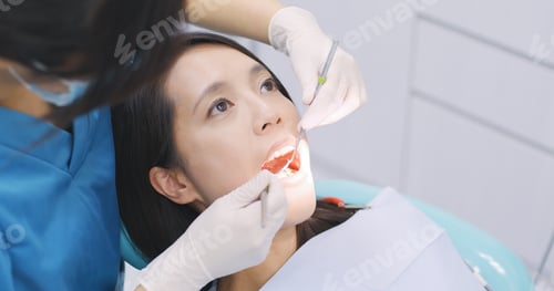 Preview: Dentist examining a patient teeth in the dentist