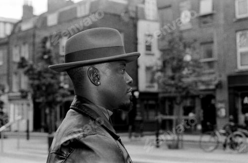 Preview: Side portrait taken with flash of man wearing a hat in the street.