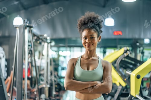 Preview: Portrait of African sport girl in sportwear exercising in fitness club.
