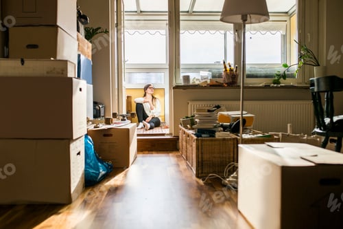 Preview: Woman resting on balcony while moving house