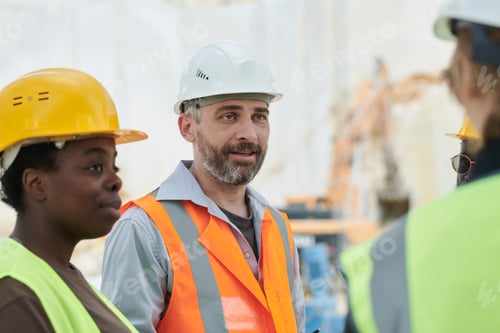 Preview: Middle aged manager of team of marble quarry workers talking to subordinates