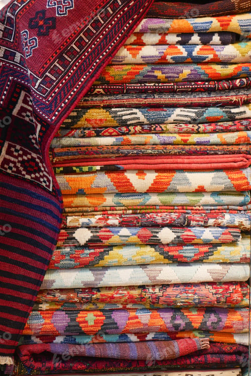 Preview: Colorful woven textiles displayed in a market setting