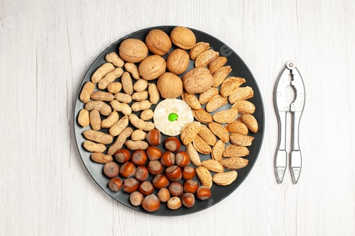 Preview: top view nuts composition fresh walnuts peanuts and hazelnuts inside plate on white desk nut tree