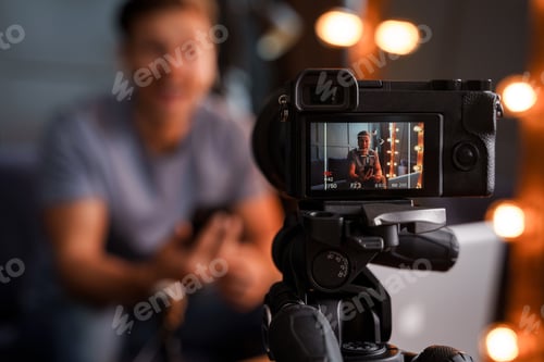 Preview: Bearded blogger sitting on a sofa is looking into a camera and smiling