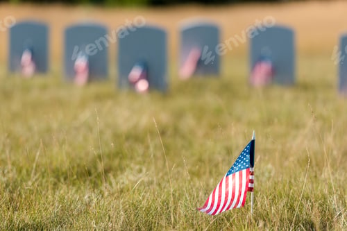 Preview: selective focus of american flag with stars and stripes near gravestones