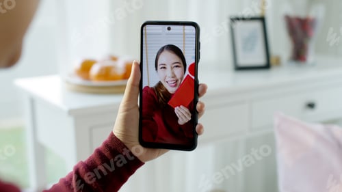 Preview: Point of view selfie videocall shot of attractive beautiful young asian lady in red chinese new year