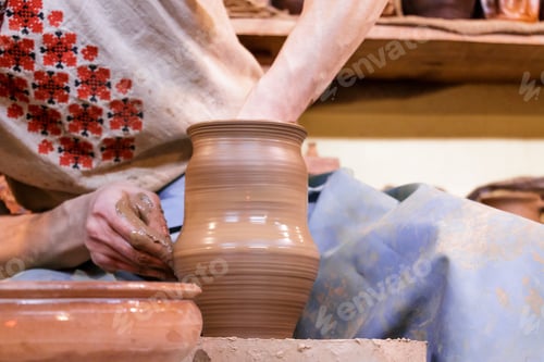 Preview: Male hands are molding a vase from clay. Work on the potter's wheel