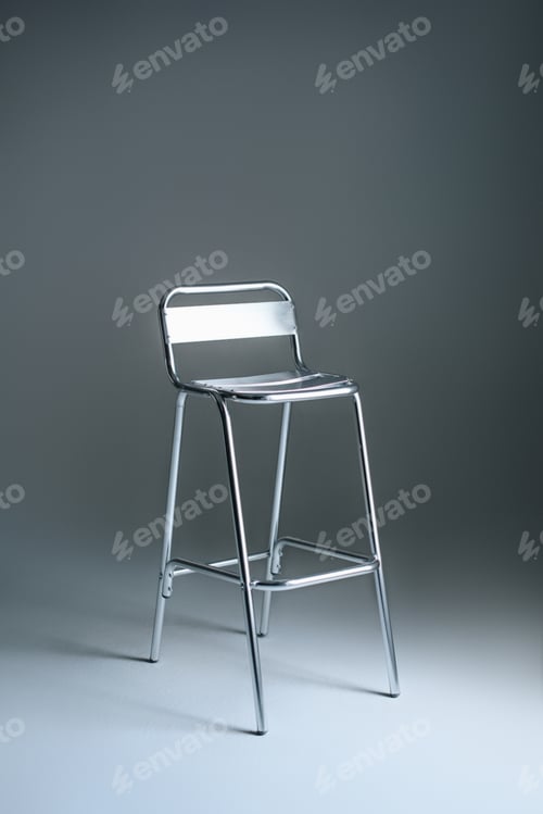 Preview: single empty metallic stool on grey