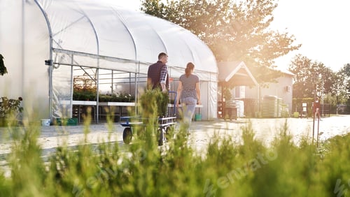 Preview: Two garden center workers pulling a transport trolley