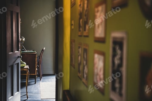 Preview: View along corridor with vintage pictures on green wall, open brown wooden door to study with