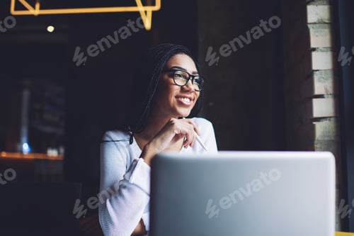 Preview: Cheerful black woman with laptop in cafe
