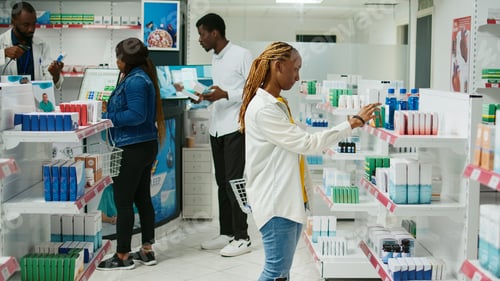 Preview: African american woman checking boxes of medicine