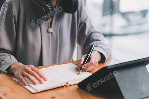 Preview: Young attractive female manager working on digital tablet while sitting in modern office.