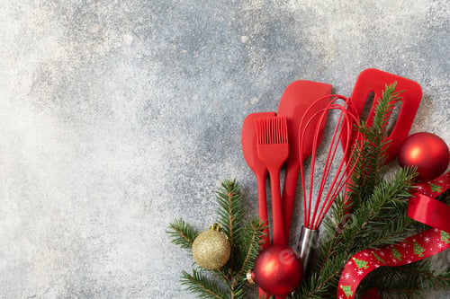 Preview: Various red kitchen baking utensils Christmas on gray stone background.