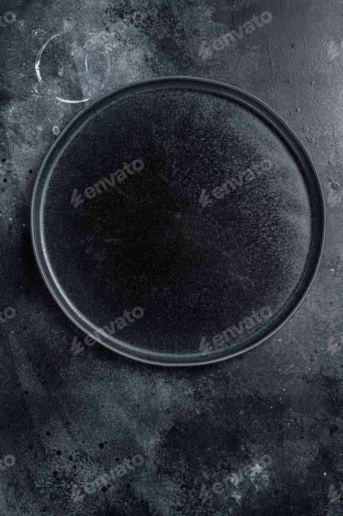 Preview: Empty black craft plate on table. Table setting. Black background. Top view. Copy space