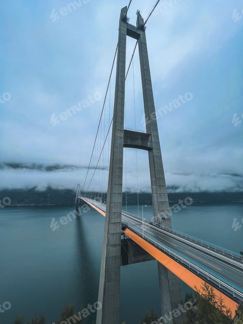 Preview: Close up of Hardanger bridge stretches across a vast expanse of ocean with clouds hovering over