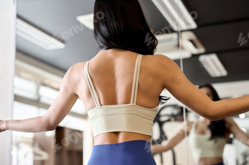 Preview: Woman posing in front of a gym mirror