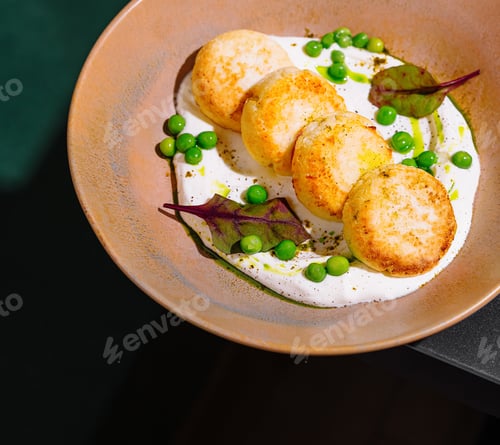 Preview: Delicious chicken cutlets being served on a plate with green peas and sauce