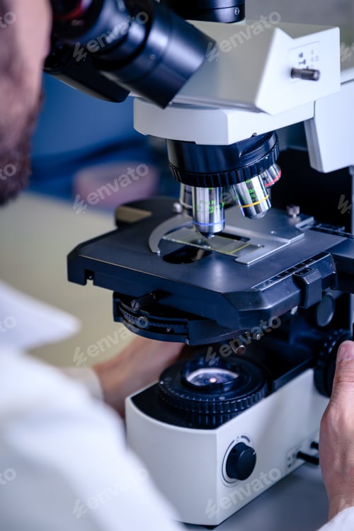 Preview: A laboratory worker working with a modern microscope while conducting a coronavirus research