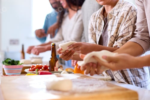 Preview: Close Up Of Group Of Friends At Home In Kitchen With Making Pizzas For Party Together