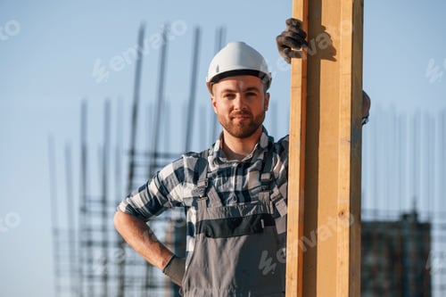 Preview: Standing and posing. Man is working on the construction site at daytime