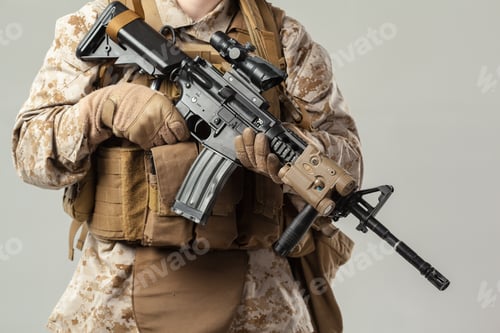 Preview: Military soldier holds rifle while wearing tactical gear in indoor setting