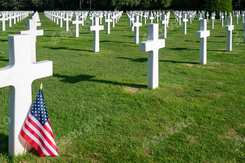 Preview: American flag standing at the gravestone of a killed soldier at the war cemetery in Normandy