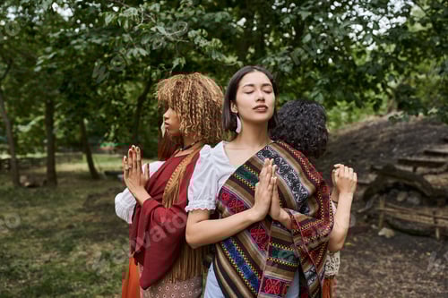 Visualização: jovens mulheres inter-raciais fazendo gestos de mãos em oração enquanto estão em um centro de retiro ao ar livre