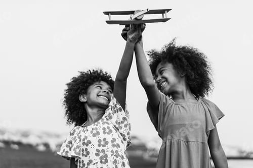 Preview: Afro twins sisters running on the beach while playing with wood airplane