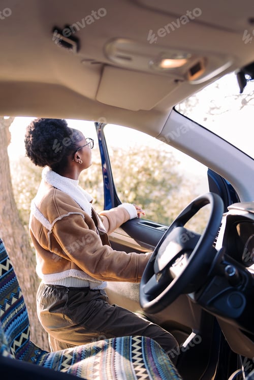 Preview: young woman in a journey standing by a camper van