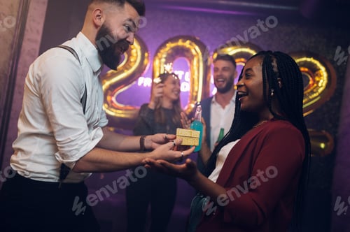 Preview: Happy beautiful couple celebrate New Year's Eve and exchanging gifts