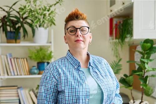 Preview: Portrait of smiling middle-aged woman in glasses with red haircut