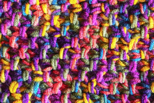 Preview: Colorful hand crochet or knitting textile fabric texture. Close up macro background.