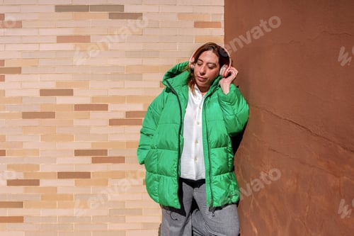 Preview: Young woman enjoying music with headphones, relaxing and expressing personal style outdoors