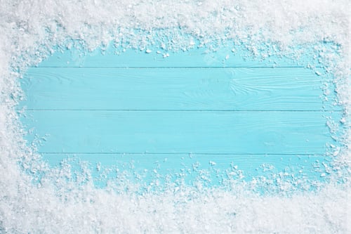 Preview: Frame of white snow on light blue wooden background, top view with space for text. Christmas season