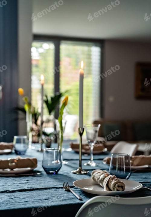 Preview: Tablescape. Table with tablecloth and candles served for lunch or dinner in the house.