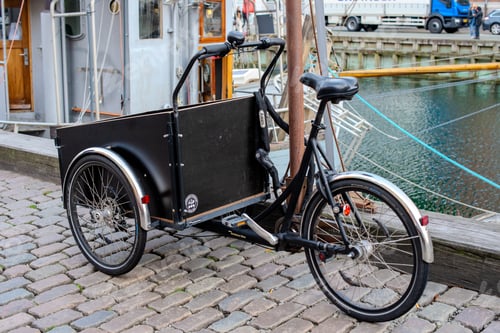Preview: Bicycle with covered cargo trailer parked by a boat.