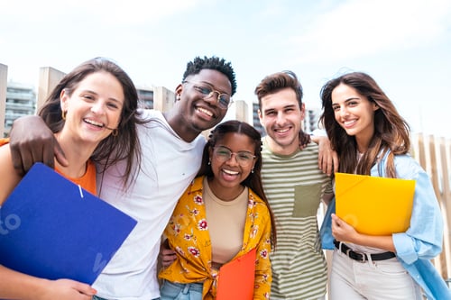 Preview: multiethnic group of cheerful students standing together outdoors with folders looking at camera -