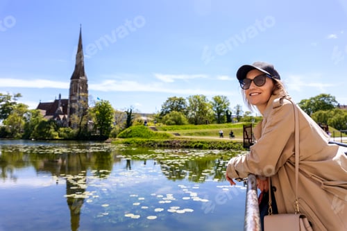 Preview: Portrait young beautiful happy smiling womane wear biege trench coat enjoy walking Kastellet citadel
