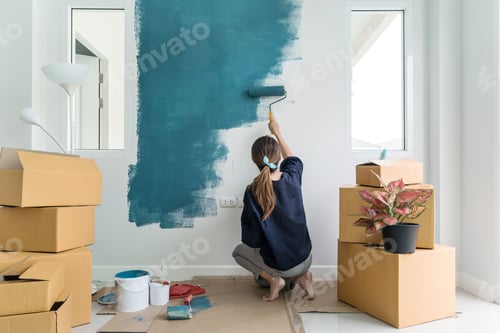 Preview: Young asian happy woman painting interior wal