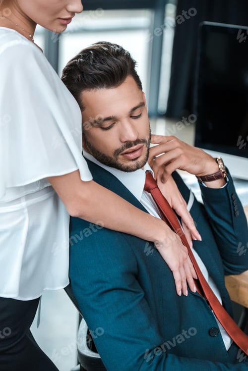 Preview: cropped view of woman standing near handsome bearded man in office