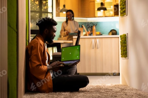 Preview: Chroma key screen on laptop with black man relaxing on floor at home