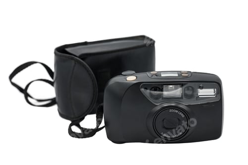 Preview: old compact camera with its black case on a white background. It is the typical compact zoom camera