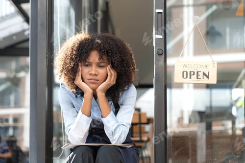 Preview: black woman waiter of street cafe is waiting for clients, customersm she is bored, no people in