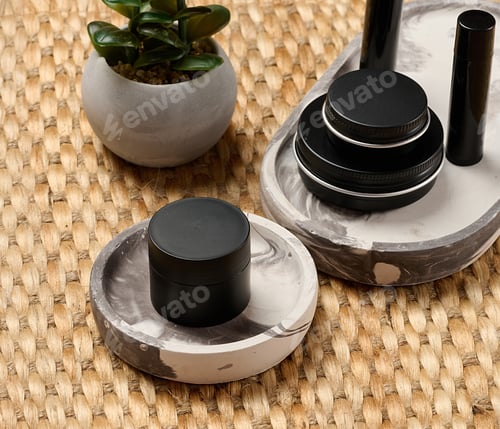 Preview: Black metal cosmetic jars and tubes on a decorative tray.
